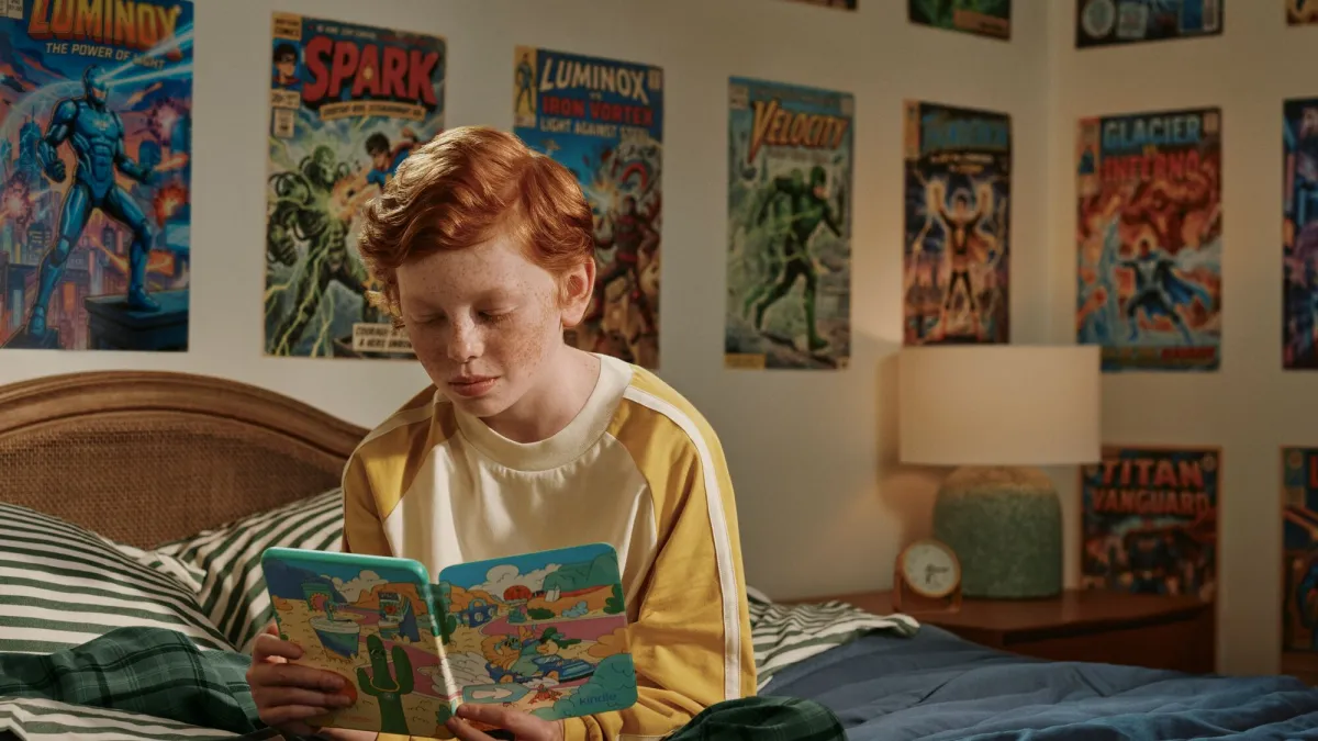 Child reading a color picture book on a Kindle Colorsoft