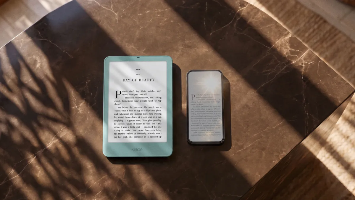 Kindle Paperwhite on a table next to a phone
